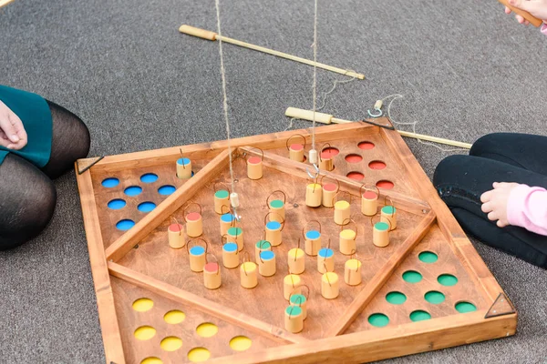 Çocuk oyunları ile renkli şekiller. Ahşap bir şekil üzerinde yem yakalamak. Rakamlar yerlerde yerleştirin. Çocuklar için oyunlar eğitim