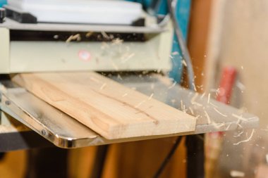 Tahta üstünde belgili tanımlık makine işleme. Talaş uçar. Düzey yönetim kurulu. Marangozluk aracı. Ev atölye.