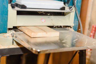 Tahta üstünde belgili tanımlık makine işleme. Talaş uçar. Düzey yönetim kurulu. Marangozluk aracı. Ev atölye.