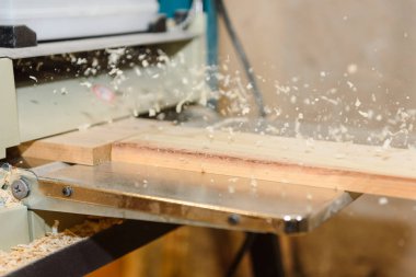 Tahta üstünde belgili tanımlık makine işleme. Talaş uçar. Düzey yönetim kurulu. Marangozluk aracı. Ev atölye.