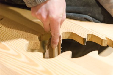 Bir adam bir ağaç bir zımpara kağıdı ile parlatır. Doğrama atölyesinde çalışmak. Ağaç pürüzsüz olması. El İşçiliği. Kaba çizgili kağıt