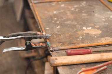 Marangozluk dükkanda kaynak ile çalışır. Metal parçalar kaynak. Tehlikeli sanayi. Kıvılcımlar.