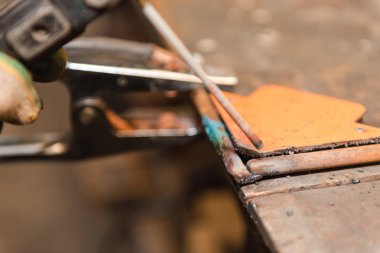 Marangozluk dükkanda kaynak ile çalışır. Metal parçalar kaynak. Tehlikeli sanayi. Kıvılcımlar.