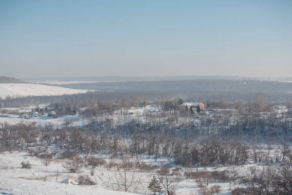 Winter view of the village from above. Houses in the snow. Countryside under the snow. Village in Siberia in the winter.