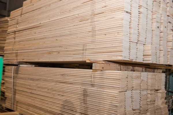 Wooden boards in a stack. Pine boards. A lot of lumber. Warehouse wooden boards.