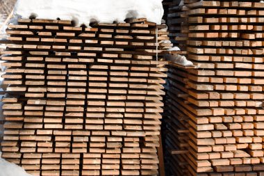 Ahşap kar altında yatıyor. Boyutlanmış kereste layzima. Boyutlanmış ağaca karda.