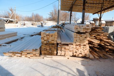 Ahşap kar altında yatıyor. Boyutlanmış kereste layzima. Boyutlanmış ağaca karda.