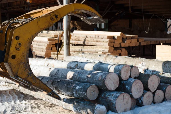 Traktör günlükleri yükler. Elinden alınan günlükleri. Manipülatör günlükleri yükler. Ağaçları kesti. Kamyonda günlükleri
