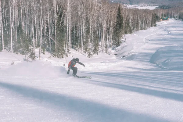 Un esquiador cabalga desde una alta montaña. Estación de esquí. Estilo de vida activo. Sanidad . — Foto de Stock