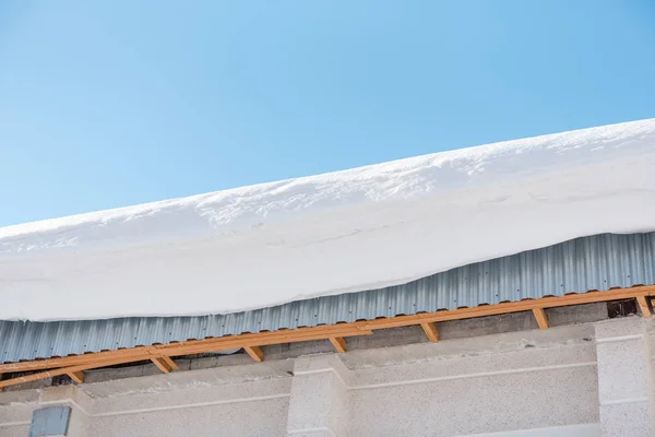 Sníh na střeše. Na střeše se snáší velký sníh. Střecha v zimě. — Stock fotografie