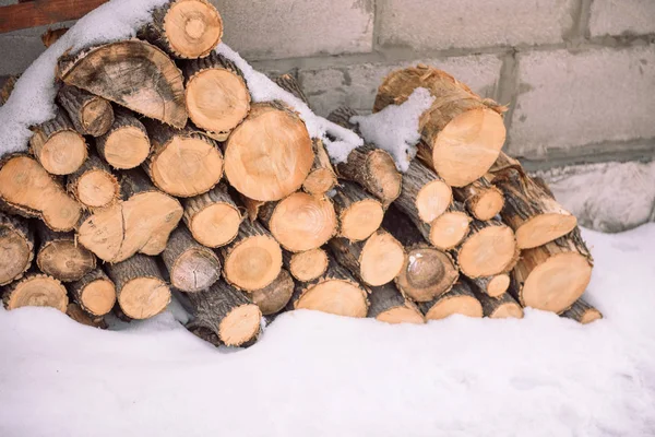 Дрова под снегом. Дрова зимой. Отходы от дерева. Дерево пилы. Деревянные леса лежат под снегом . — стоковое фото