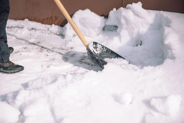 Odśnieżanie z łopatą. Człowiek łopaty łopaty do odgarniania śniegu. Łopata do śniegu w ręku. Czyszczenie obszaru w zimie. — Zdjęcie stockowe