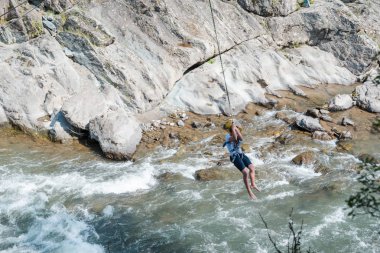 Nehrin üzerinden bungee jumping. Aşırı eğlence. Bir dağ nehrinin üzerinden atla. pürüzlü nehir.