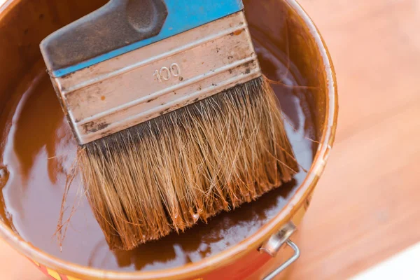 Boyada geniş bir fırça. Terası fırçala. Fırça boya kutusunda yatıyor. Boyada mavi fırça.