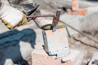 Çimentodaki tuğla Çimentoyu kaldırın. Tuğla bir duvarı yıkıyorum. Tuğlalara vuruyor. Tuğla parçalarını kaldırın. Bölgeyi enkazdan temizliyorum. Tuğla çit yapımı. Sıkı çalışma.