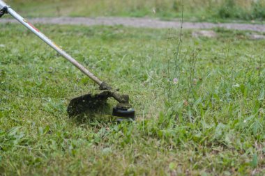 Çimleri biçme makinesiyle kes. Çimleri kesin. Çimleri kesin. Erkek işçi. Açık hava işi. Cihazla çimleri kesin. Meslek