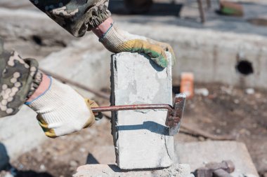 Çimentodaki tuğla Tuğladan yapılma. Tuğla bir duvarı yıkıyorum. Temiz tuğlalar. Çimentoyu kaldırın. İnşaat. Sıkı çalışma.