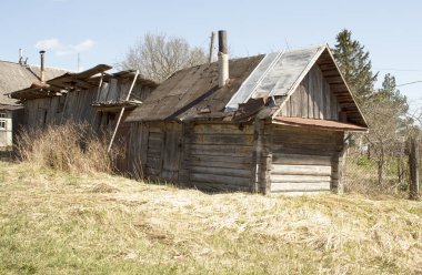 Bir boru ile eski terk edilmiş ahşap ev. Bahar
