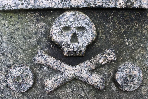 Cráneo y huesos cruzados en una placa de piedra —  Fotos de Stock