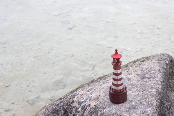 Bir oyuncak deniz feneri bir taşın üzerinde duruyor. Yukarıdan görüntüle.