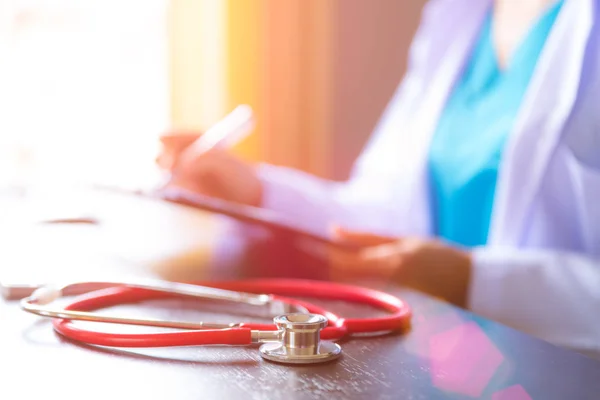 Mjukt Fokus Röda Stetoskop Arbetsbord Med Kvinnliga Läkare Handen Håller — Stockfoto