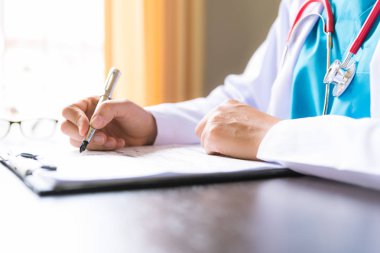 Kadın doktor el başvuru formu tutarak yumuşak odak veya ofis masası bilgisayar ile onay listesini. Sağlık ve tıp kavramı.