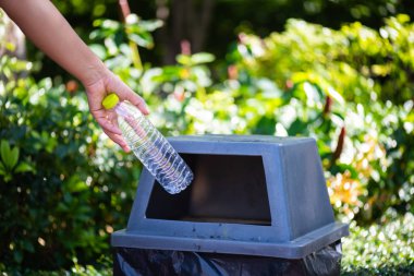 Dünya Çevre günü, 5 Haziran. Kadın el holding ve plastik şişe atık çöp çöp kutusuna koyarak.