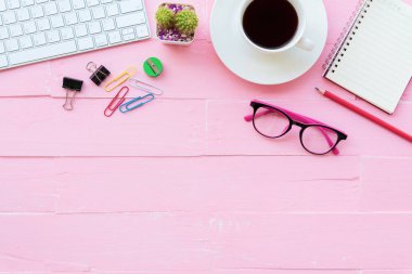 Üstten görünüm Ofis masaları dahil olmak üzere klavye, Gözlük, klipler, çiçek, kalem, Not defteri, belge ve kahve pembe ahşap arka plan üzerinde kırpma çalışma alanı ve ofis aksesuarları ile.