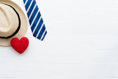 Mutlu babalar günü kavramı. Üstten görünüm kırmızı kravat, el yapımı kırmızı kalp ve parlak beyaz pastel ahşap masa arka plan üzerine şapka.