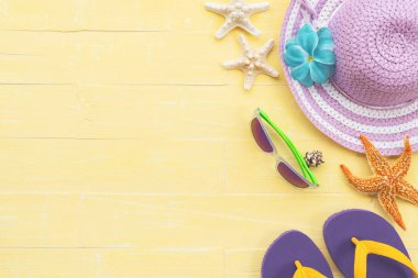 Plaj aksesuarları dahil olmak üzere güneş gözlüğü, deniz yıldızı, şapka plaj, renkli flip flop ve deniz kabuğu parlak pastel ahşap arka plan için mavi yaz tatil ve tatil kavramı üzerinde.