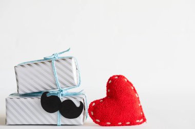 Mutlu babalar günü kavramı. Bıyık ve handmane güzel hediye kutusu yığını beyaz zemin üzerine kırmızı kalp.
