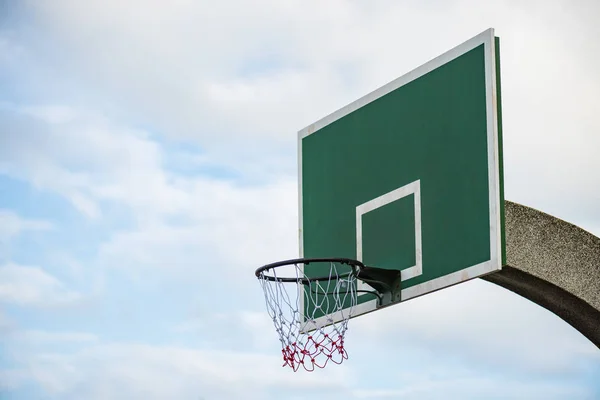 Basketball board with hoop net on blue sky white cloud.