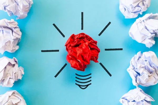 Inspiration and great idea concept. light bulb with crumpled colorful paper on blue background.