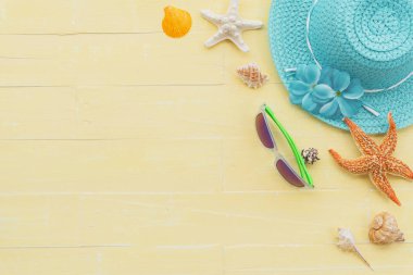 Plaj aksesuarları dahil olmak üzere güneş gözlüğü, deniz yıldızı, şapka plaj, renkli flip flop ve deniz kabuğu parlak pastel ahşap arka plan için mavi yaz tatil ve tatil kavramı üzerinde.