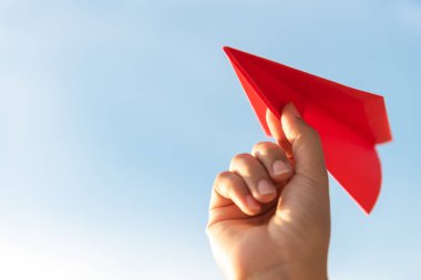 Kırmızı kağıt roket mavi gökyüzü arka plan ile tutan kadın el. Özgürlük kavramı.
