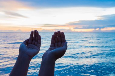 Gün batımı arka plan sırasında Tanrı'dan nimet için dua eller yumuşak odak ve siluet kadın. Umut kavramı.