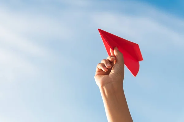 青い空を背景に赤の紙のロケットを持つ女性の手 自由の概念 — ストック写真
