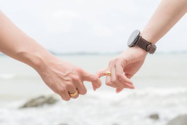 Aşk sembolleri. Deniz ve gökyüzü arka plan bulanık için sevgi ve Sevgililer günü kavramı üzerinde bir arada tutan adam ve kadın çift el