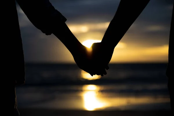 爱的象征 剪影夫妇人和妇女手一起举行在海和天空背景在日落期间为友谊天 爱和情人节概念 — 图库照片