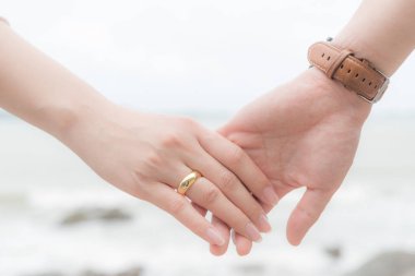 Aşk sembolleri. Deniz ve gökyüzü arka plan bulanık için sevgi ve Sevgililer günü kavramı üzerinde bir arada tutan adam ve kadın çift el