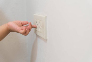 Bebek el ile elektrik soketi, tehlikeli durum evde oynarken yumuşak odak.