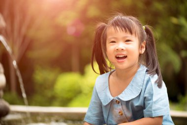 Sıcak yaz gününde renkli bahçe suda oynarken mutlu küçük kız. Çocuklar için yaz etkinlikleri.