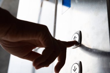 Waman yandan basın üst üst düzey kat için binada asansör bir yukarýya düðme kapatın.