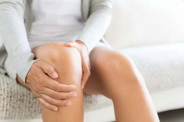 Closeup Young Woman Sitting Sofa Feeling Knee Pain She Massage — Stock Photo, Image