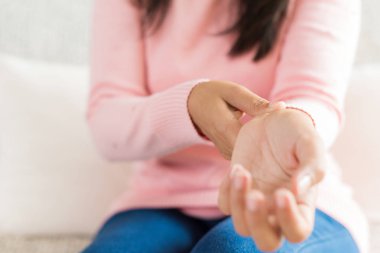 Koltukta oturan Closeup kadın onu bilek el yaralanması, acı hissetmiyor tutar. Sağlık ve tıp kavramı.