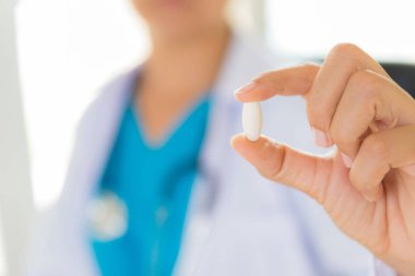 Kadın doktor stetoskop bir omuz bir hap holding ile. Sağlık ve tıp kavramı.
