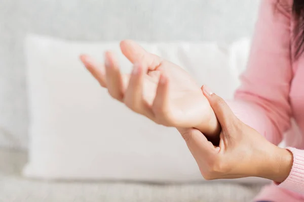 Mujer Cerca Sentada Sofá Sostiene Lesión Mano Muñeca Sintiendo Dolor — Foto de Stock