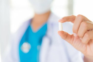 Kadın doktor stetoskop bir omuz bir hap holding ile. Sağlık ve tıp kavramı.