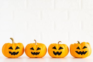 Beyaz tuğla blok zemin üzerine sarı hayalet balkabağı. Cadılar Bayramı kavramı.