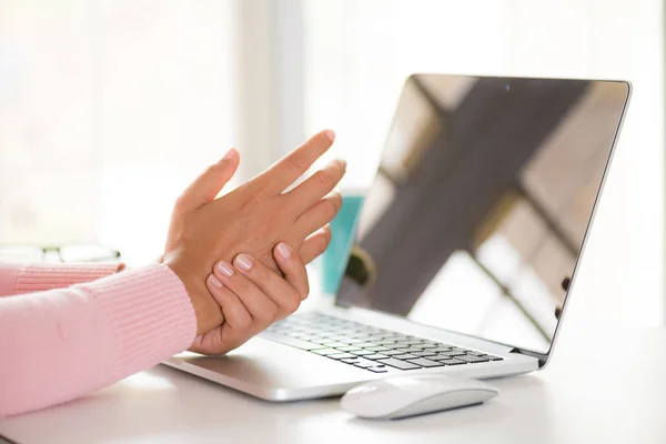 特写女人抱着她的手腕疼痛从使用计算机 办公室综合征手疼痛的职业病 — 图库照片